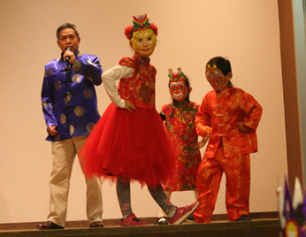 Children performing a cultural dance and song, wearing traditional Asian clothing at a Dia event, a celebration of children and books